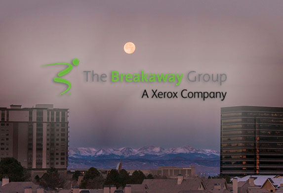 Denver Tech Center skyline with a full moon and the mountains at sunrise and the logo for the Breakaway Group, a Xerox Company